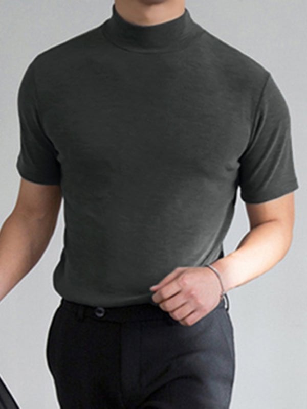 Mand i mørkegrå t-shirt med høj hals og korte ærmer, iført sorte bukser. Moderne herremode, minimalistisk stil, casual outfit.