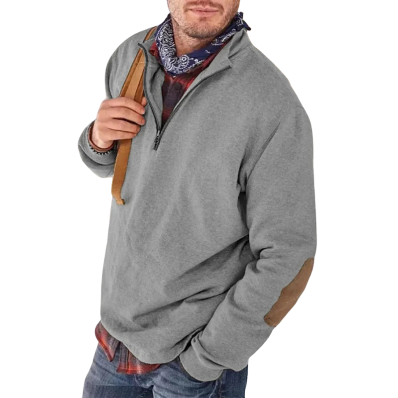 Grå herretrøje med lynlås og albuelapper, bæres over rødternet skjorte. Perfekt til casual mode og efterårsoutfits.