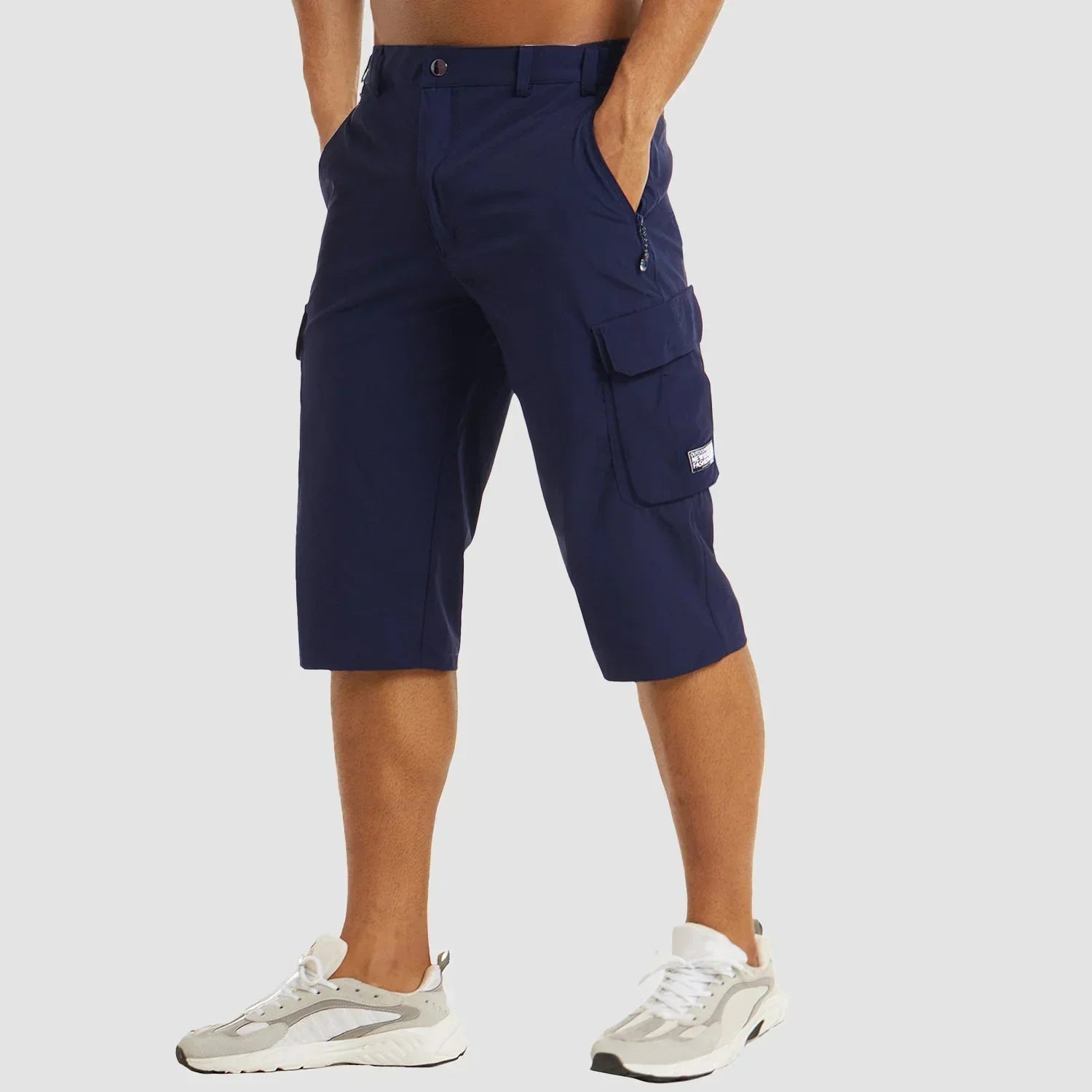 Mørkeblå cargoshorts til mænd, knælange med lommer, bæres af model i hvide sneakers. Perfekt til sommermode og afslappet stil.