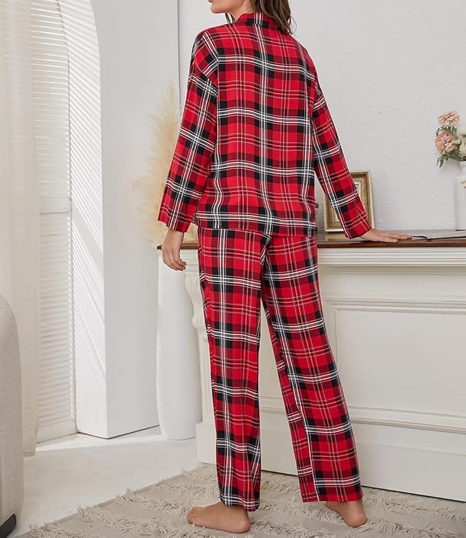 Kvinde iført rødternet pyjamas i stue, stående ved hvid kommode. Komfortabelt nattøj, moderne plaid design, afslappet hjemmestil.