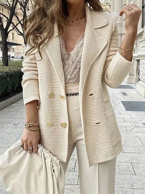 Kvinde iført elegant beige blazer og blondebluse, gående på byens fortov. Mode, stilfuldt tøj, moderne kvindemode, byliv.