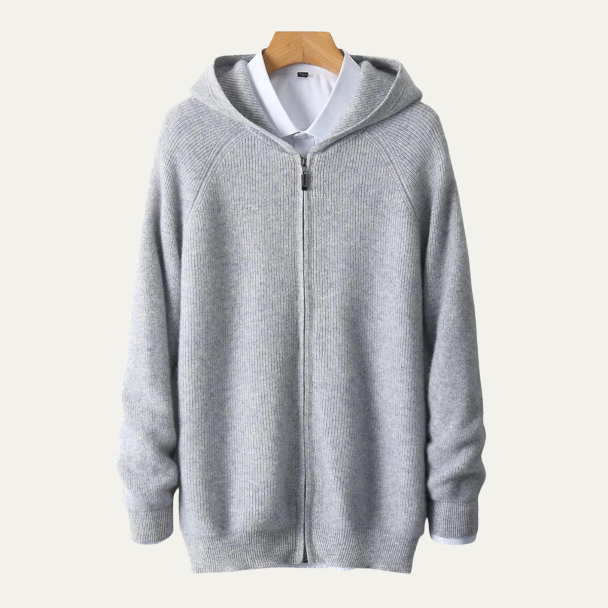 Grå hættetrøje i uld med lynlås, hængende på bøjle. Stilfuld og varm trøje til efterår og vinter. Perfekt til casual og komfortabelt look.