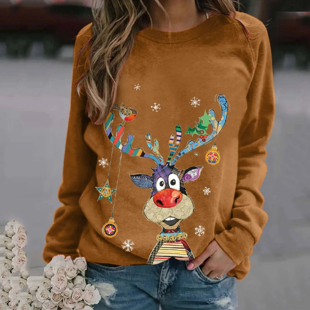 Kvinde iført brun sweatshirt med farverigt rensdyrmotiv, snefnug og julepynt. Perfekt til julemode og vintertøj. Casual og festlig stil.