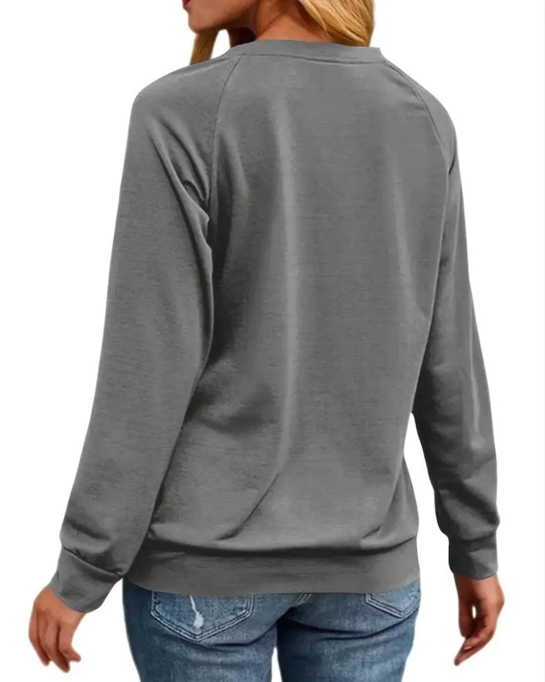 Kvinde iført grå sweatshirt og blå jeans set bagfra. Komfortabelt hverdagstøj, afslappet stil, langærmet trøje, mode til kvinder.