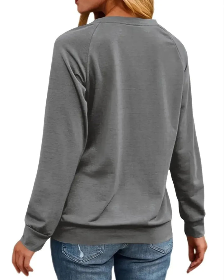 Kvinde iført grå sweatshirt og blå jeans set bagfra. Komfortabelt hverdagstøj, afslappet stil, langærmet trøje, mode til kvinder.