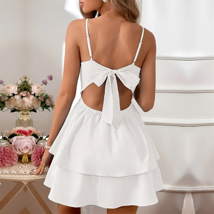 White mini dress with overlapping ruffles, spaghetti straps and airy cut