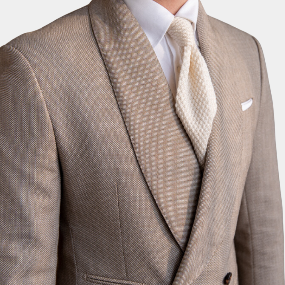 Beige jakkesæt med hvid skjorte og tekstureret slips. Elegant herremode, klassisk stil, formelt tøj.