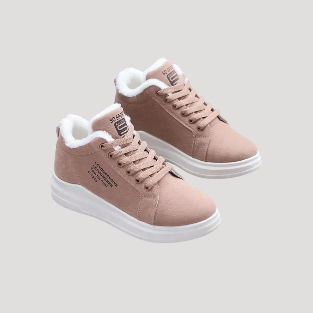 Lyserøde sneakers med hvid pelsforing, flade såler og snørebånd. Moderne vinterfodtøj til kvinder, komfortable og stilfulde sko.