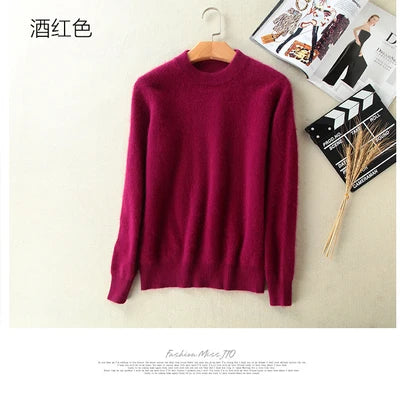 Vinrød uldtrøje hængende på bøjle mod lys væg, ved siden af modeblade og tørrede blomster. Stilfuld, varm sweater til efterår og vinter.