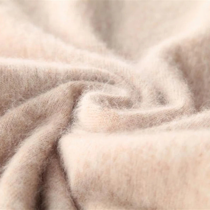 Blødt beige kashmirstof i nærbillede, viser tekstur og kvalitet. Perfekt til luksuriøse trøjer og tørklæder. Kashmir tekstil, blødt materiale.