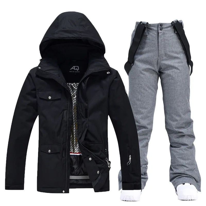 Sort skijakke med hætte og grå skibukser med seler. Vintertøj til ski og udendørs aktiviteter. Vandtæt og vindtæt skitøj til mænd.