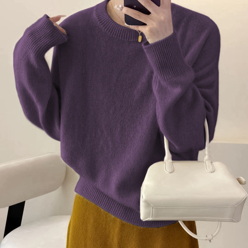 Person iført lilla sweater og gul nederdel, holder en hvid håndtaske. Moderne mode, stilfuldt outfit, trendy farvekombination.