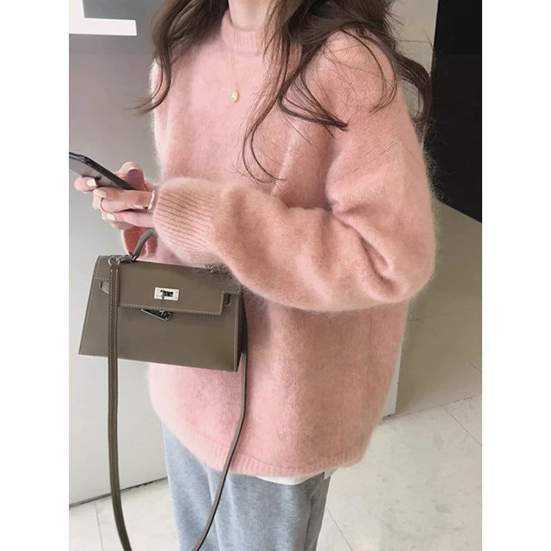 Kvinde i lyserød sweater med smartphone og brun håndtaske. Moderne mode, casual stil, efterårsoutfit, trendy accessories, komfortabelt look.