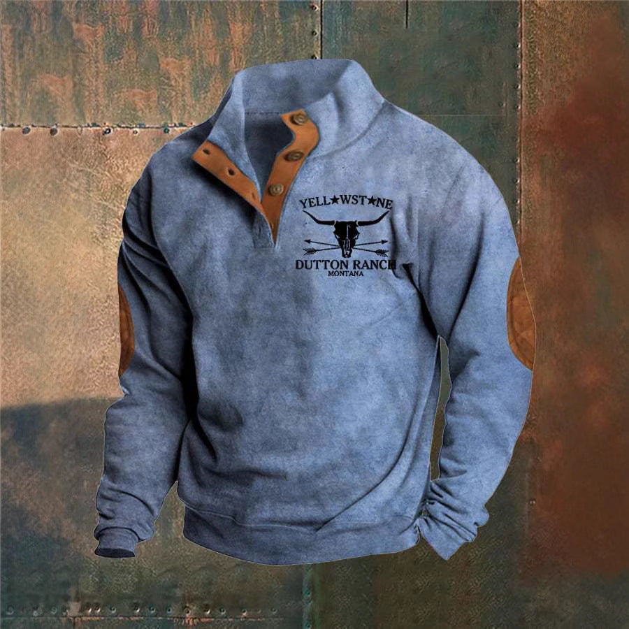 Grå sweatshirt med Yellowstone Dutton Ranch-logo, Montana. Designet har brune albuelapper og knapdetaljer. Populær mode, casual stil.