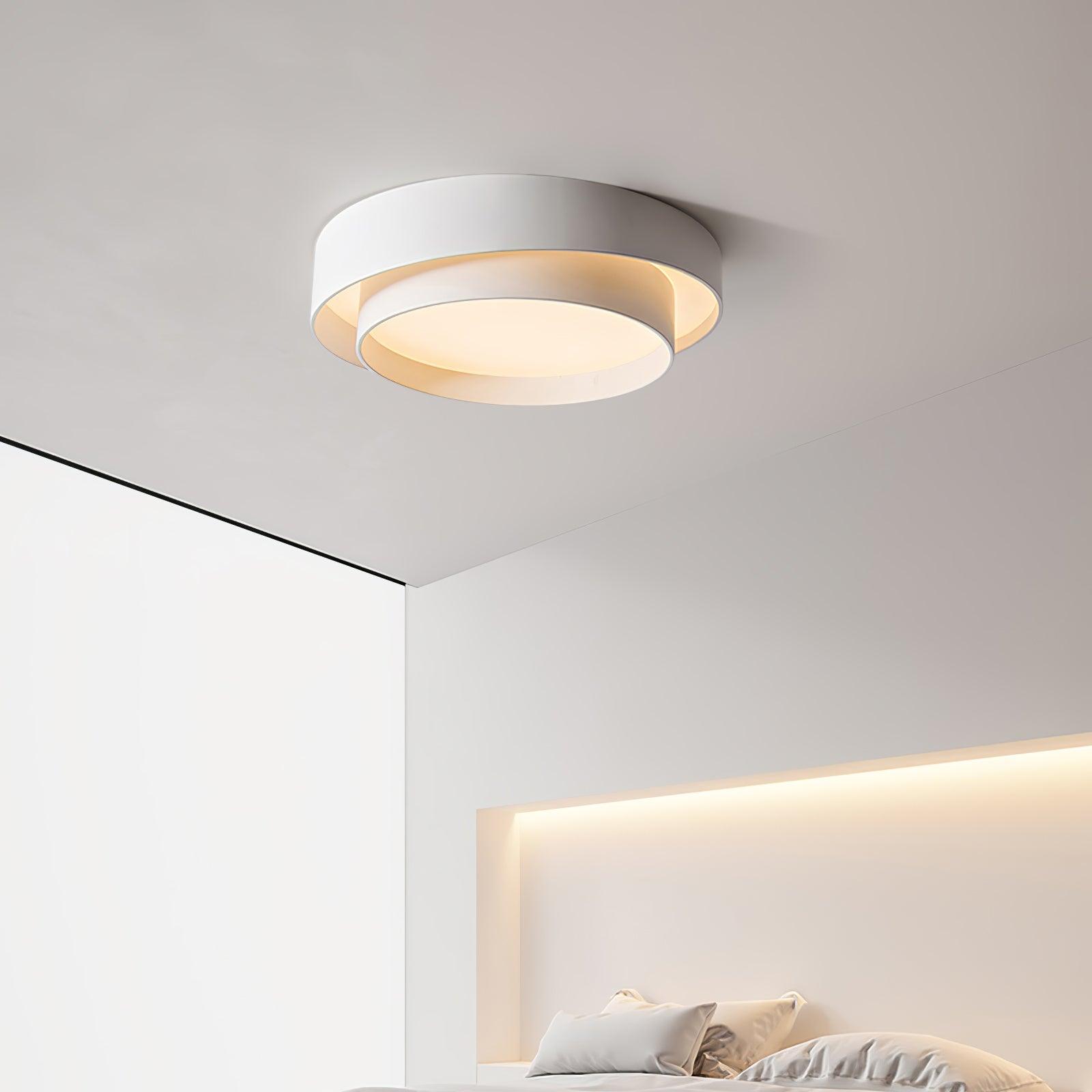 Moderne hvid loftlampe i minimalistisk design over seng i soveværelse. LED-belysning, energibesparende, stilfuld indretning, skandinavisk stil.