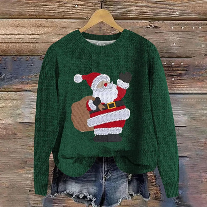 Grøn julesweater med julemanden motiv, hængende på træbaggrund. Perfekt til jul, vintermode, hyggelig striktrøje, festlig beklædning.