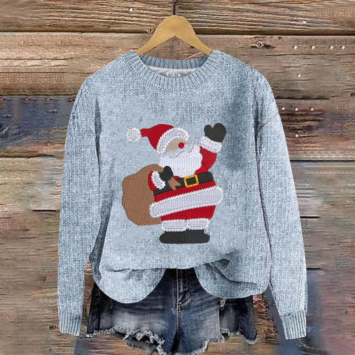 Grå julesweater med julemanden-motiv, hængende på træbaggrund. Perfekt til jul, vintermode, hyggelig strik, festlig beklædning.