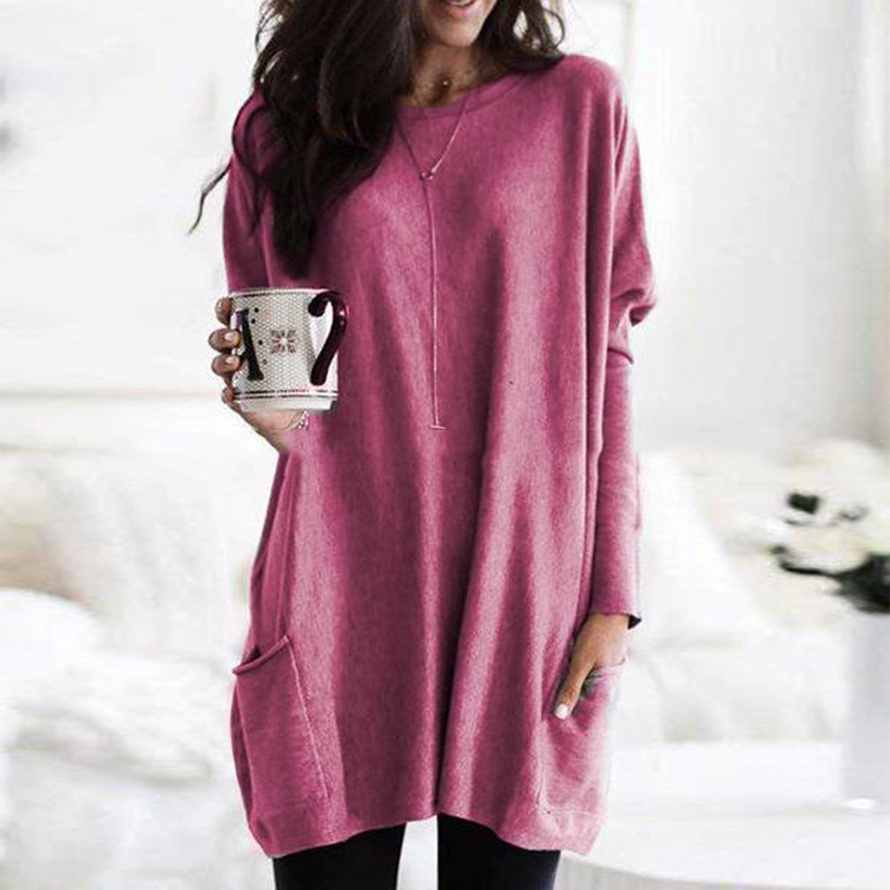 Kvinde iført lyserød oversized sweater, holder en kop kaffe. Komfortabelt vintertøj, afslappet stil, hygge. Perfekt til hjemlig afslapning.