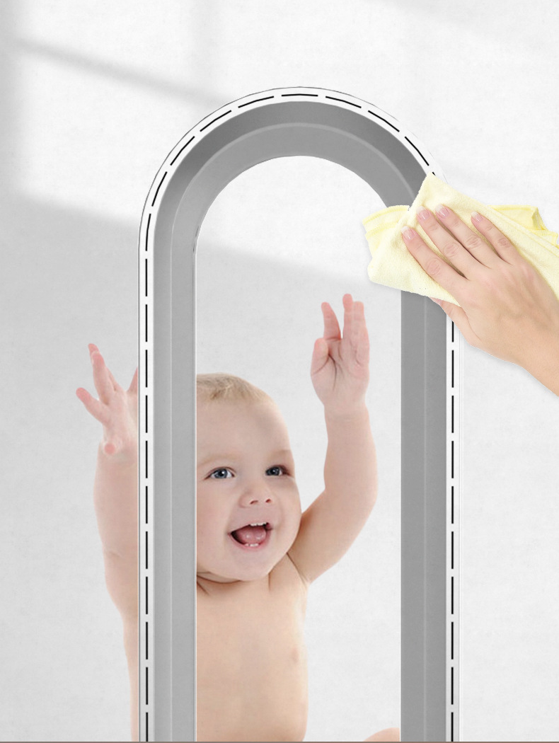 Baby leger med ventilator uden blade, mens en hånd tørrer den ren. Moderne blæserdesign, sikkerhed for børn, rengøring af ventilator.