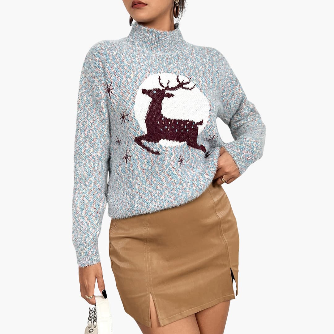 Kvinde iført lyseblå sweater med rensdyrmotiv og beige nederdel. Moderne vintermode, striktrøje, stilfuldt outfit til kolde sæsoner.