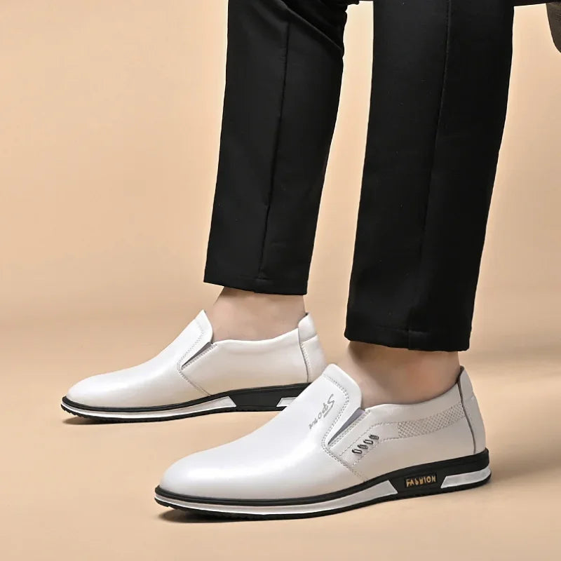 Hvide herresko i læder med sort sål, bæres af person i sorte bukser. Moderne slip-on design, ideel til stilfulde og komfortable outfits.