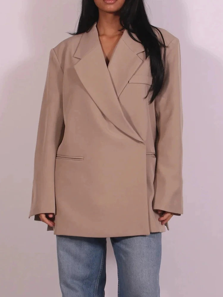 Beige oversized blazer til kvinder, moderne design, bæres over lyseblå jeans. Stilfuldt og trendy look til hverdagsbrug.