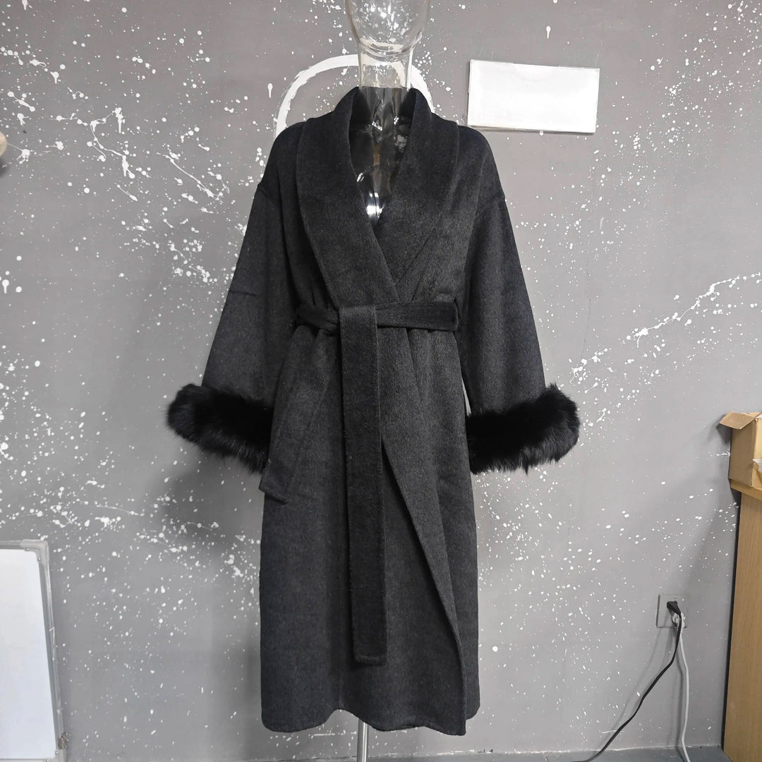 Mørkegrå frakke med bælte og sorte pelsmanchetter på mannequin. Elegant vinterovertøj, moderne design, stilfuld beklædning til kvinder.