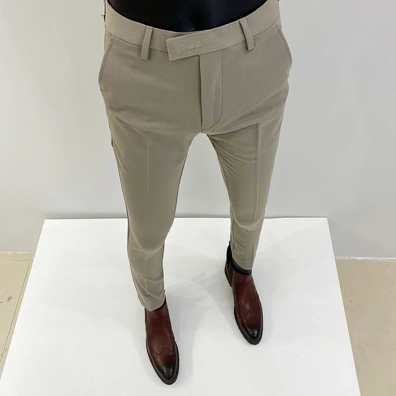 Beige herrebukser på mannequin med brune lædersko, moderne slim fit design, stilfuldt herretøj, perfekt til formelle og afslappede lejligheder.