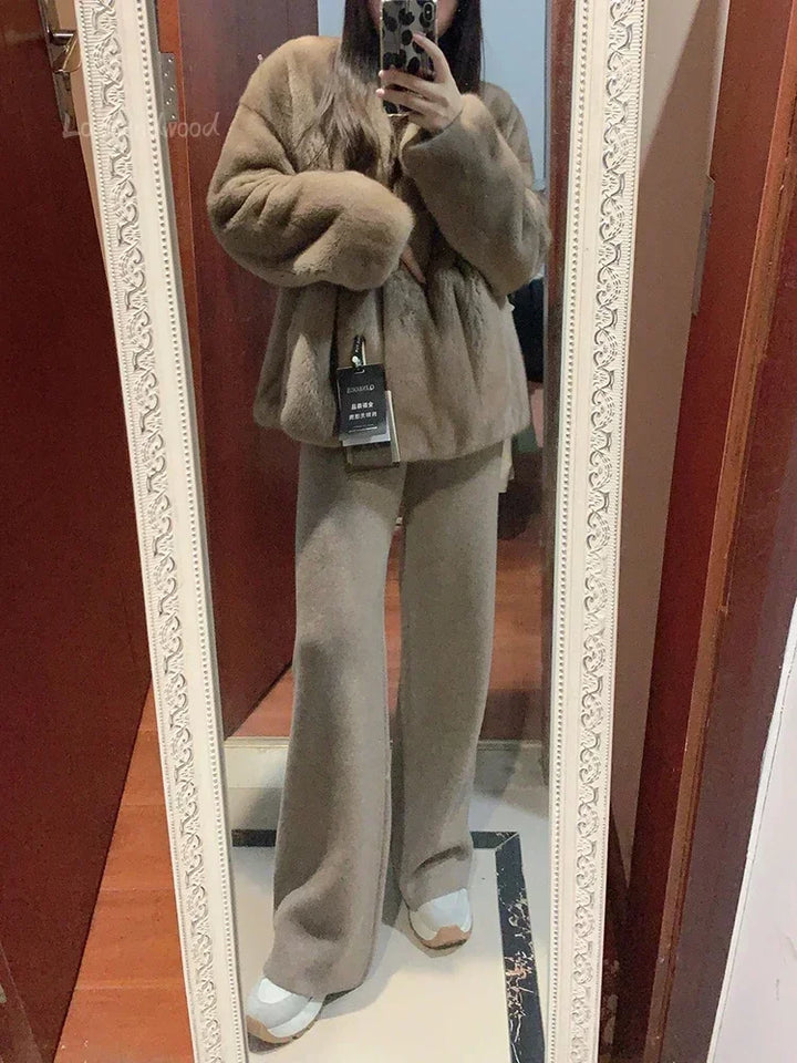 Kvinde iført brun pelsjakke og beige bukser tager spejlbillede. Mode, vintertøj, stilfuldt outfit, komfortabelt tøj, moderne kvindemode.