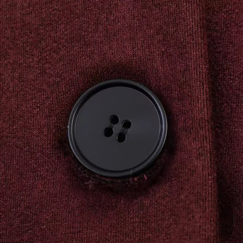 Bordeauxrød uldtrøje med sort knap, tæt på. Perfekt til efterårsmode, varm og stilfuld beklædning. Ideel til herre- og damemode.