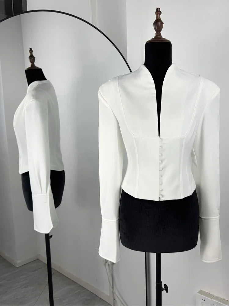Hvid, elegant blazer på mannequin med spejlrefleksion. Moderne design, lange ærmer, knapdetaljer. Perfekt til stilfulde, formelle lejligheder.