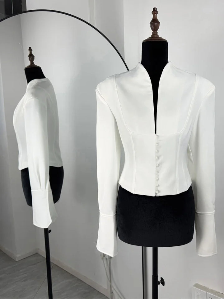 Hvid, elegant blazer på mannequin med spejlrefleksion. Moderne design, lange ærmer, knapdetaljer. Perfekt til stilfulde, formelle lejligheder.