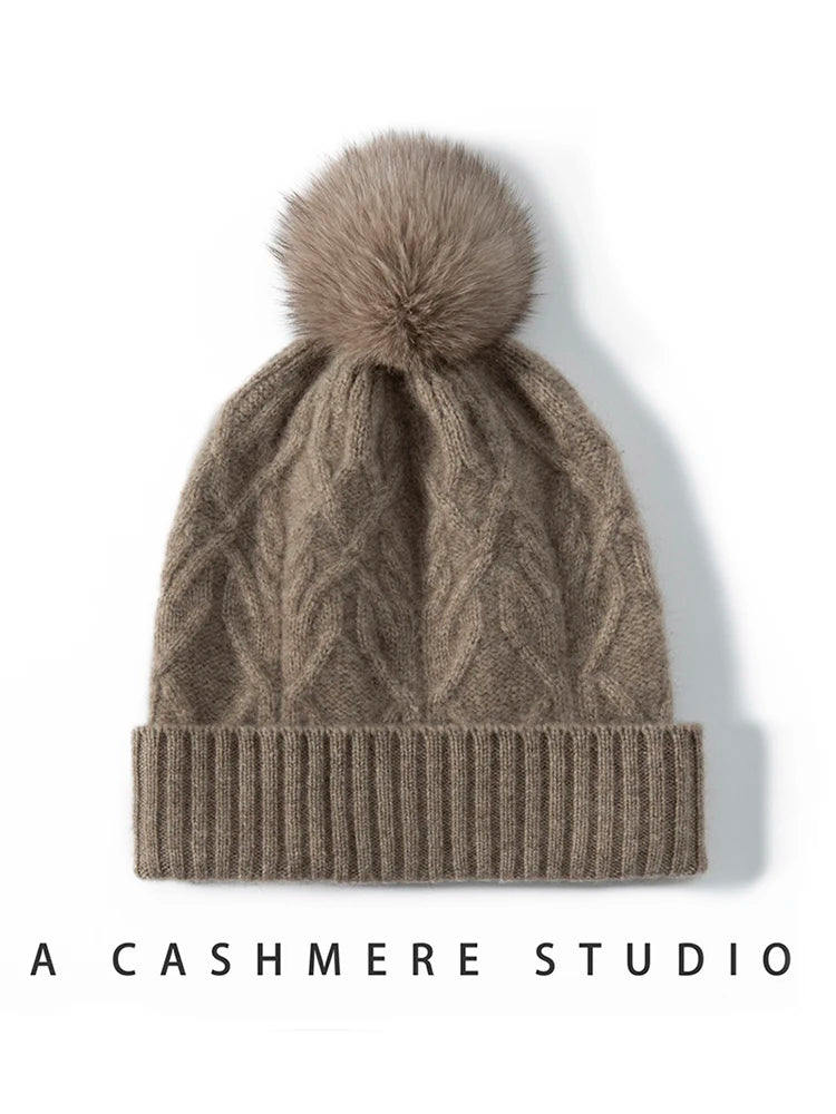 Brun kashmir hue med kabelstrik og pelskvast, stilfuldt vintertilbehør. Perfekt til varme og mode. A Cashmere Studio.