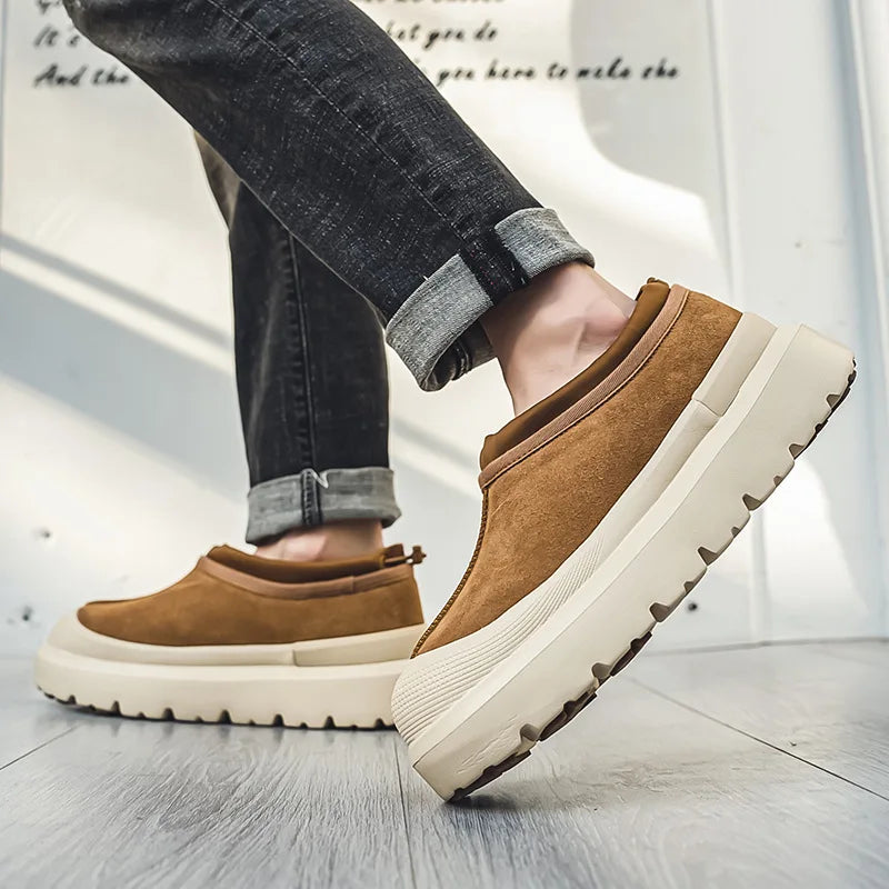 Brune herresko med tyk hvid sål, bæres af person i sorte jeans. Moderne fodtøj, casual stil, komfortable sneakers til mænd.