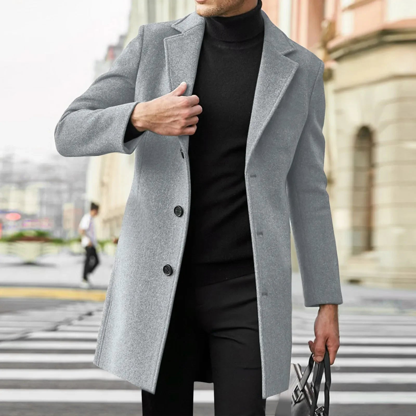 Mand iført grå frakke og sort turtleneck på byens gade. Elegant herremode, vinterjakke, stilfuldt look, moderne herretøj, urban stil.