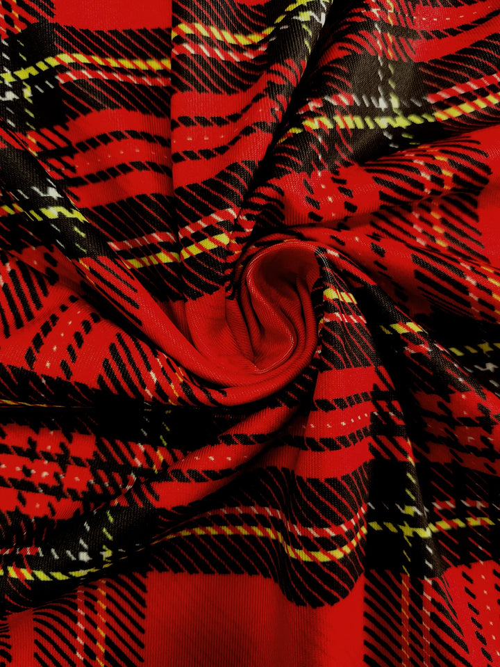 Rød skotskternet stof med sorte, hvide og gule linjer, snoet i et spiraldesign. Perfekt til mode, tekstiler og interiør.
