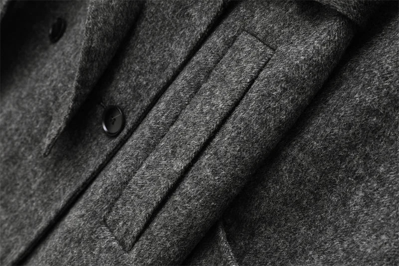 Grå uldfrakke med knapper og lomme, tæt på. Elegant vinterjakke, klassisk design, varm beklædning til mænd. Høj kvalitet stofdetaljer.