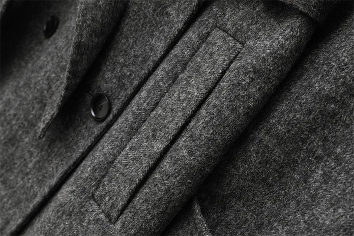 Grå uldfrakke med knapper og lomme, tæt på. Elegant vinterjakke, klassisk design, varm beklædning til mænd. Høj kvalitet stofdetaljer.