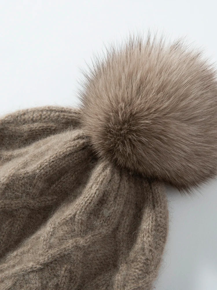 Brun strikket hue med stor pelskvast, vintermode til kvinder, varm og stilfuld beklædning, perfekt til kolde vejrforhold.