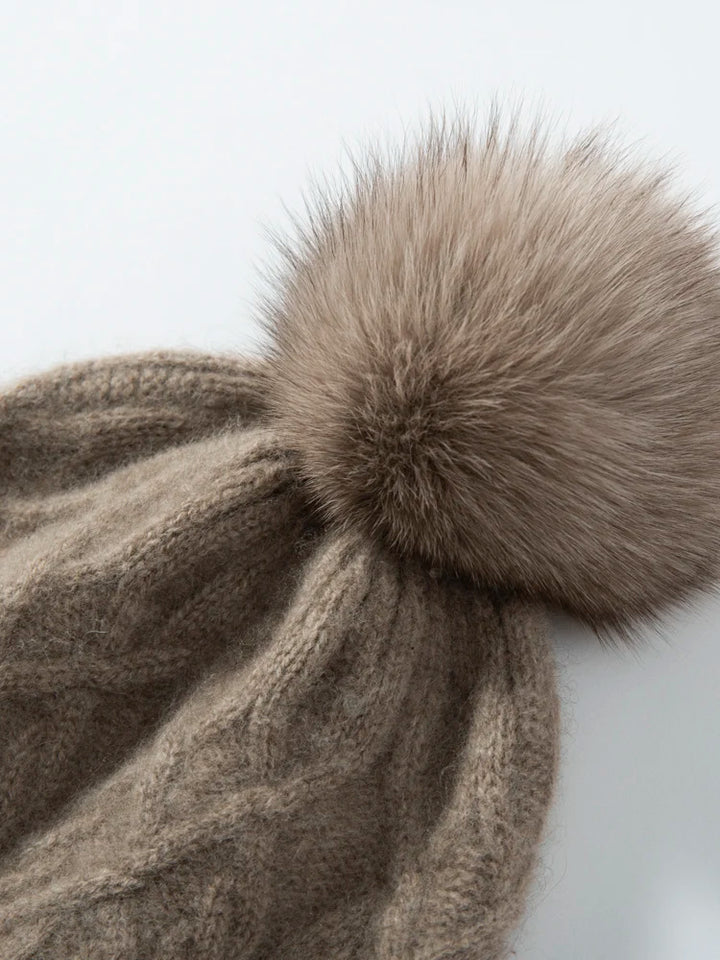 Brun strikket hue med stor pelskvast, vintermode til kvinder, varm og stilfuld beklædning, perfekt til kolde vejrforhold.