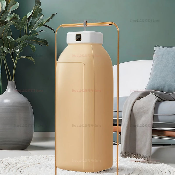 Moderne gulvlampe i form af en stor, beige mælkeflaske med hvid top, placeret i stilfuldt indrettet stue med grøn plante og grå sofa.