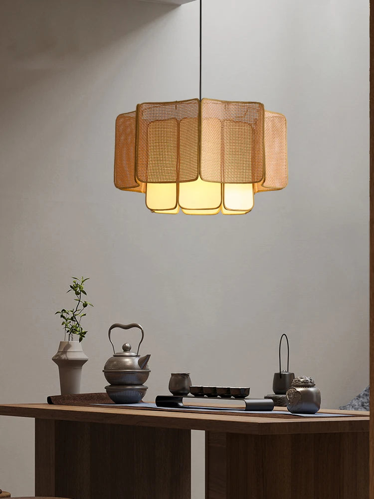 Moderne spisebord med asiatisk-inspireret te-sæt og elegant, gylden loftslampe. Minimalistisk indretning, varm belysning, stilfuldt design.