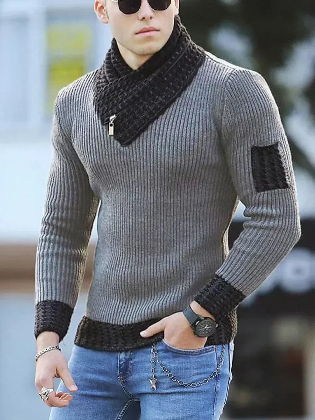 Mand i grå striktrøje med sorte detaljer, solbriller og jeans. Moderne herremode, vintertøj, stilfuldt design, afslappet look.
