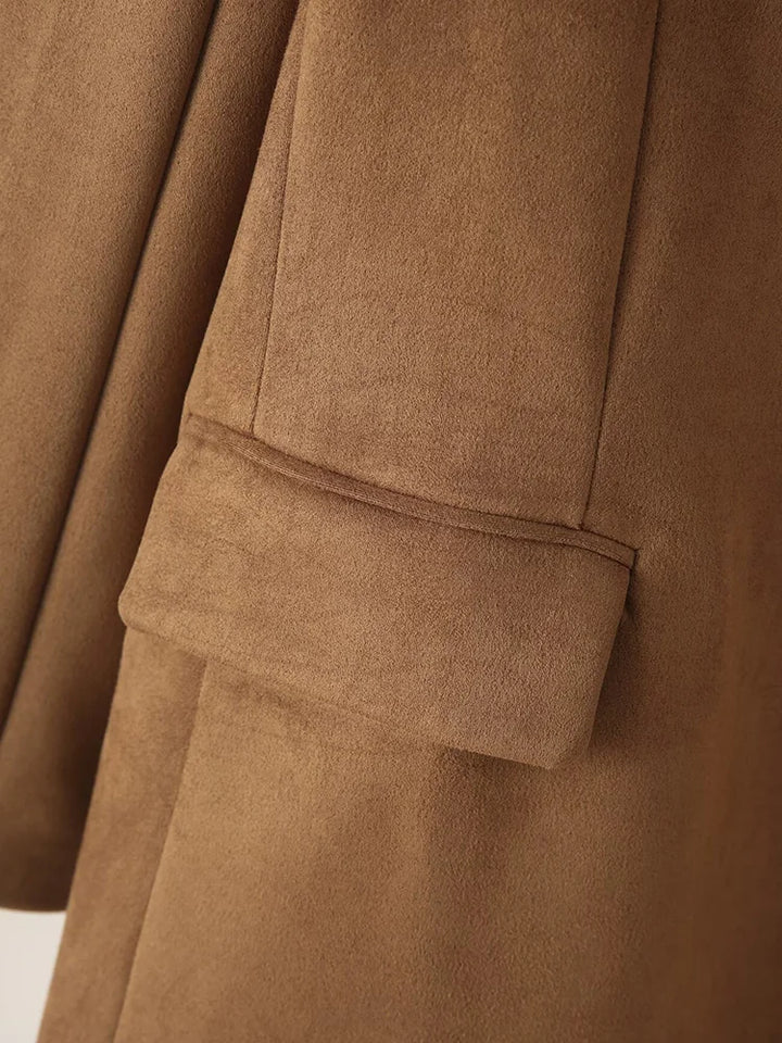 Brun ruskindsjakke med detalje af ærme og lomme. Elegant og stilfuldt design, perfekt til efterårsmode. Høj kvalitet og tidløst look.