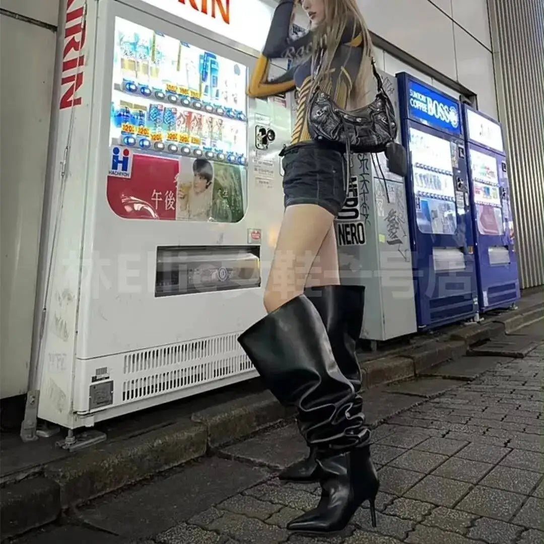 Ung kvinde i sorte lårhøje støvler og kort tøj står foran japanske drikkevareautomater. Urban mode, nat, Tokyo gade.