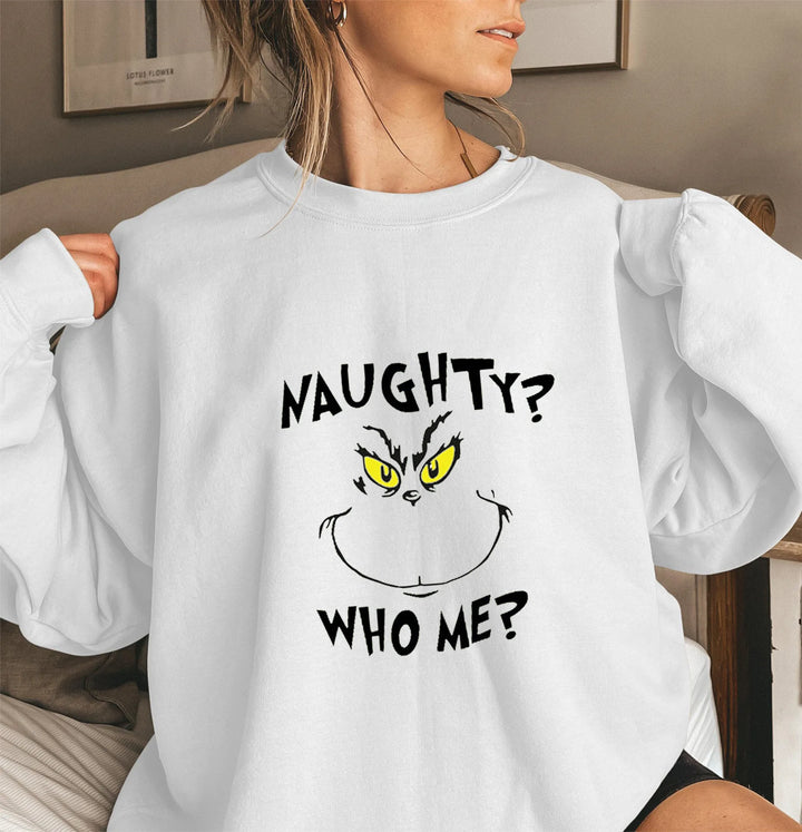 Kvinde iført hvid sweatshirt med Grinch-motiv og teksten "Naughty? Who Me?". Perfekt til jul, sjovt design, afslappet stil.