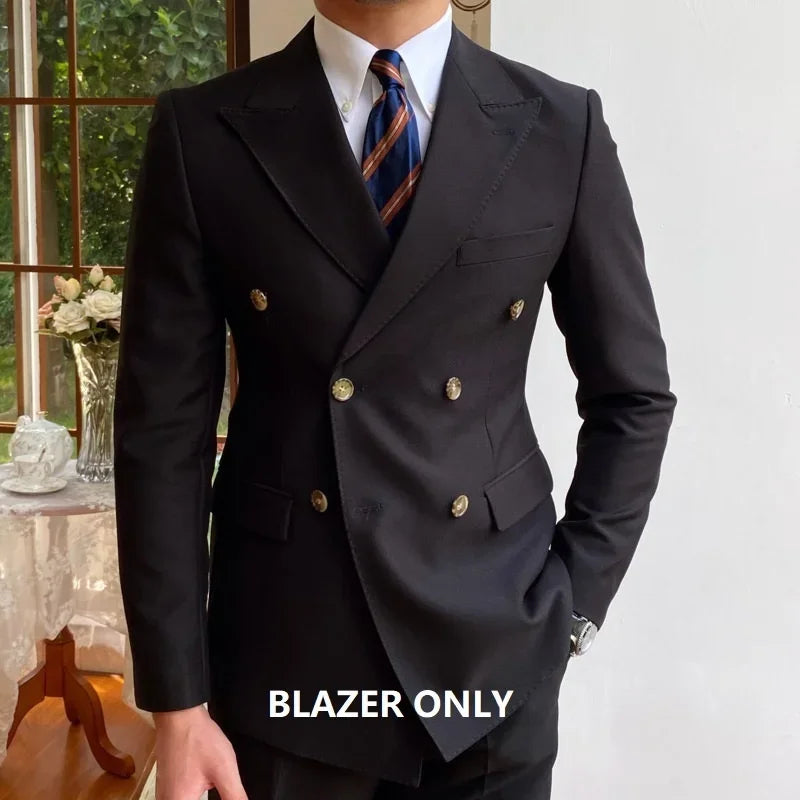 Mand i sort dobbeltradet blazer med guldknapper, hvid skjorte og stribet slips. Elegant herremode, formelt tøj, stilfuldt jakkesæt.