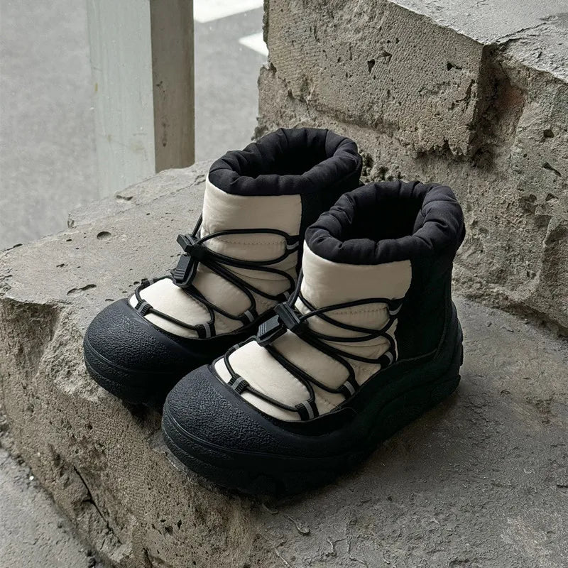 Sort-hvide vandrestøvler med snørebånd på betonoverflade. Komfortable og slidstærke sko til udendørsaktiviteter. Perfekte til vandreture og trekking.