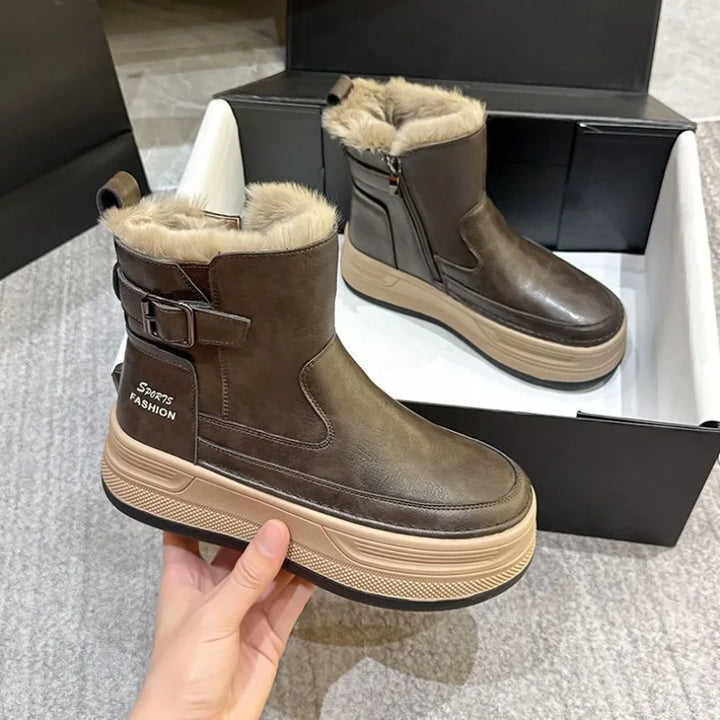 Brune vinterstøvler med pelsfor, lynlås og spænde, placeret i en skotøjsæske. Moderne design, komfortable og varme til koldt vejr.