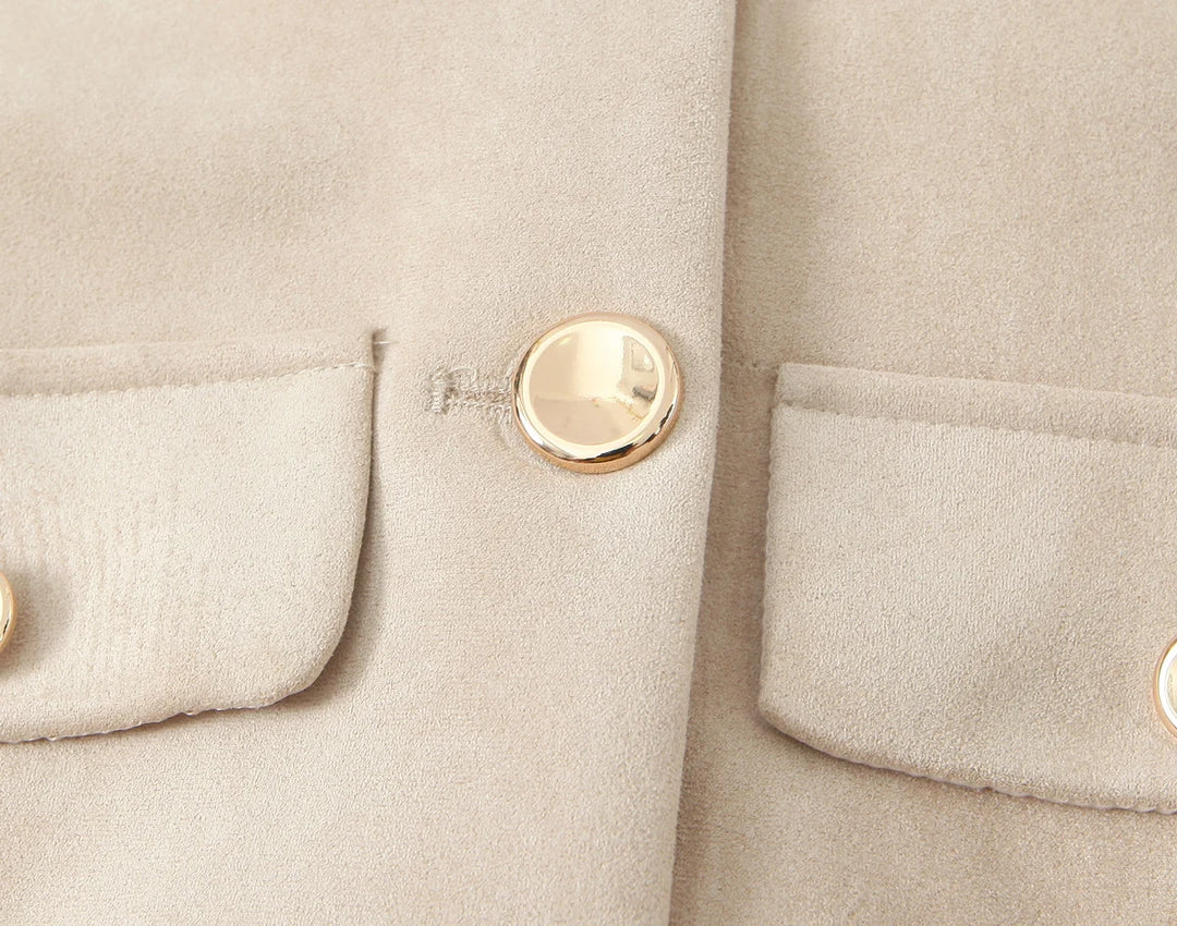 Beige ruskindsjakke med guldknapper og lommer. Elegant og stilfuldt design, perfekt til modebevidste kvinder. Luksuriøst og tidløst look.